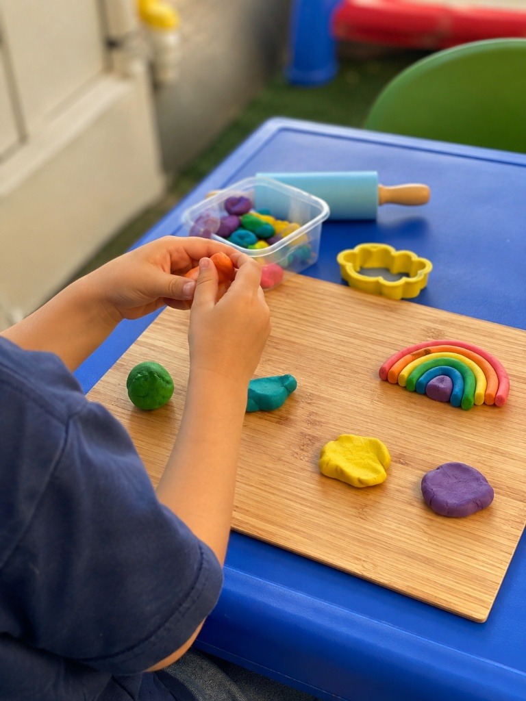 Niñera jugando con plastilina con niño